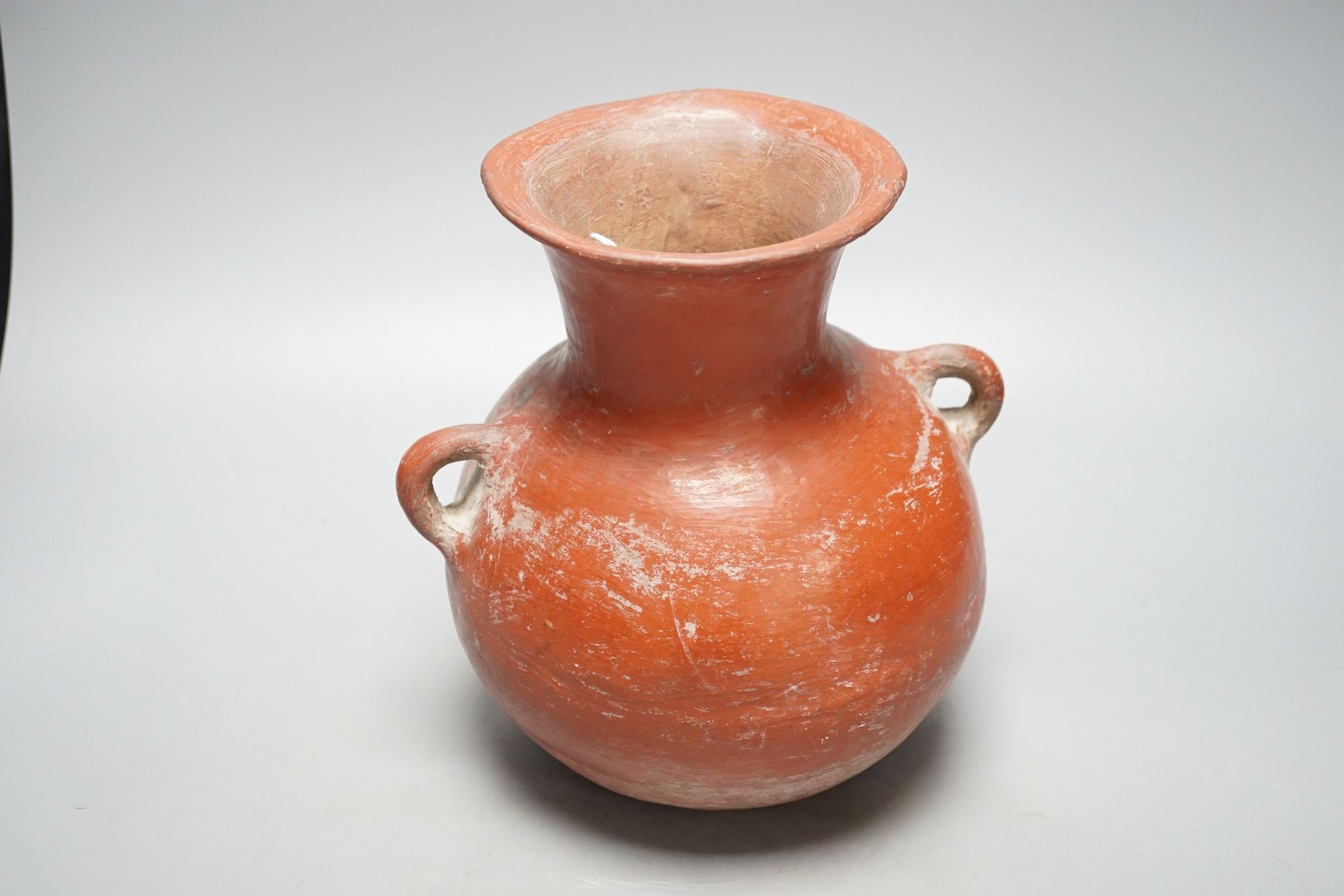 A pre-Columbian black and red pigment decorated two handled pot 25cm